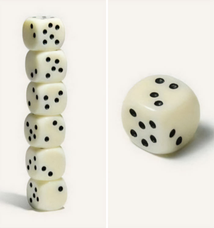 Stack of dice balanced unusually with one die separate, prompting curiosity.