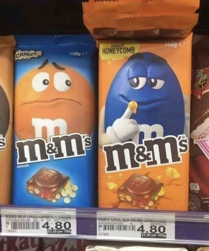 M&M's packages with expressive faces on a store shelf, one looking curious, the other puzzled.